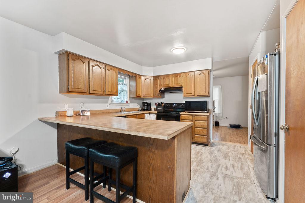 127 Saylers Creek Road Locust Grove, VA 22508 - Photo 33 of 56 a kitchen with a sink a stove a refrigerator cabinets and dining table
