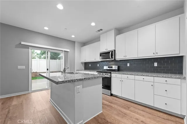 a kitchen with stainless steel appliances granite countertop a sink and cabinets