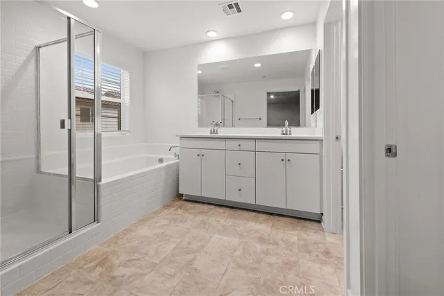 a spacious bathroom with a tub sink shower and mirror