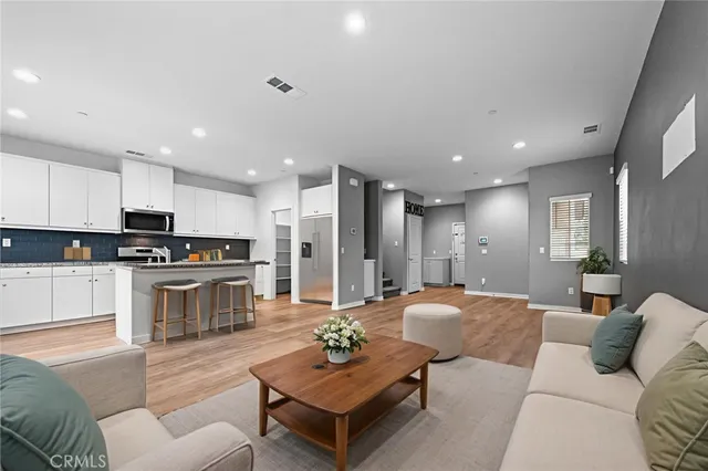a living room with stainless steel appliances kitchen island granite countertop a couch and a view of living room