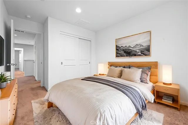 a bedroom with a bed and a painting on the wall