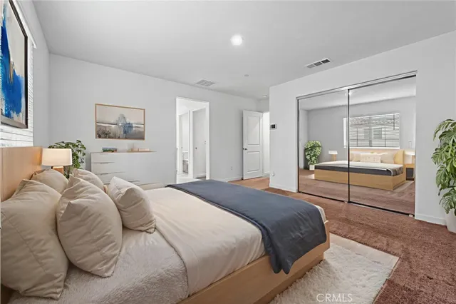 a bedroom with a balcony a bed and a view of living room