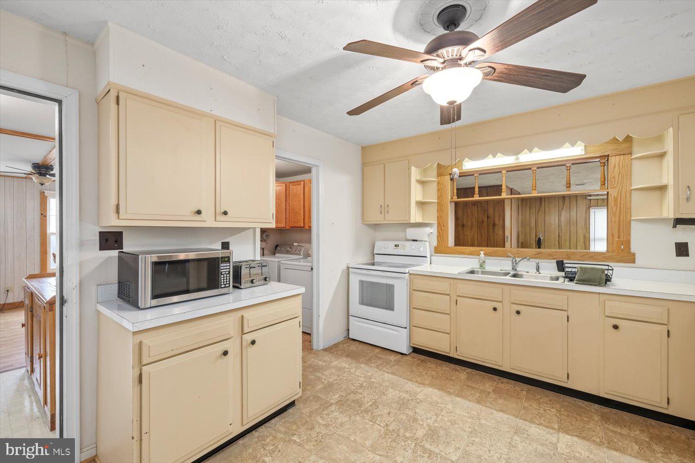110 Longfield Road Colonial Beach, VA 22443 - Photo 15 of 40 a kitchen with white cabinets and white appliances
