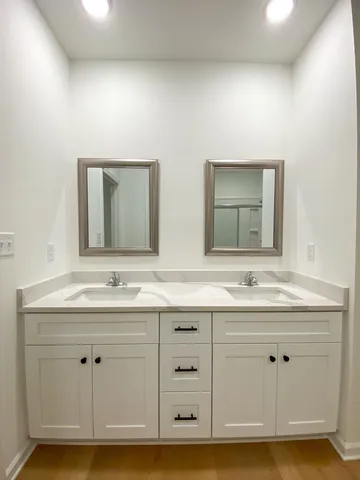 a bathroom with a double vanity sink mirror and