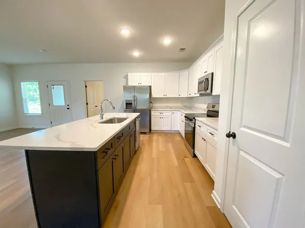 a kitchen with a sink and wooden floor