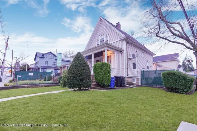 a view of a house with a big yard and large trees