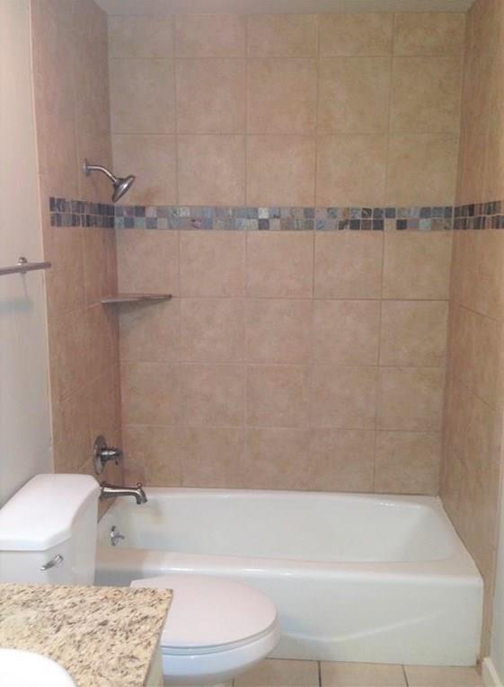 1720 Stonegate Drive Denton, TX 76205 - Photo 11 of 16 a bathroom with a bathtub and a shower