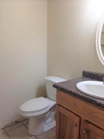 a bathroom with a granite countertop toilet and a sink