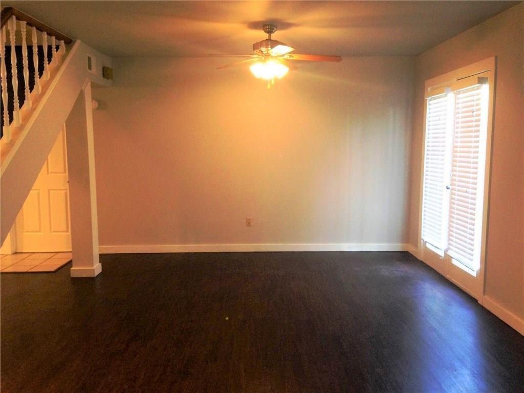 1720 Stonegate Drive Denton, TX 76205 - Photo 4 of 16 a view of an empty room with wooden floor and a window
