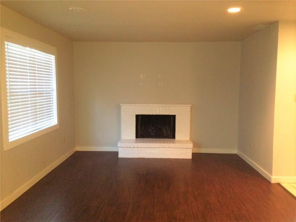 1720 Stonegate Drive Denton, TX 76205 - Photo 5 of 16 a view of an empty room with wooden floor and a window