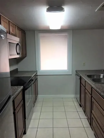 a kitchen with stainless steel appliances granite countertop a stove a sink and a microwave