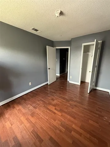 an empty room with wooden floor and entrance