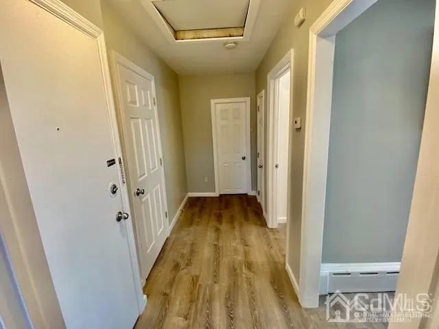 a view of a hallway with wooden floor and staircase