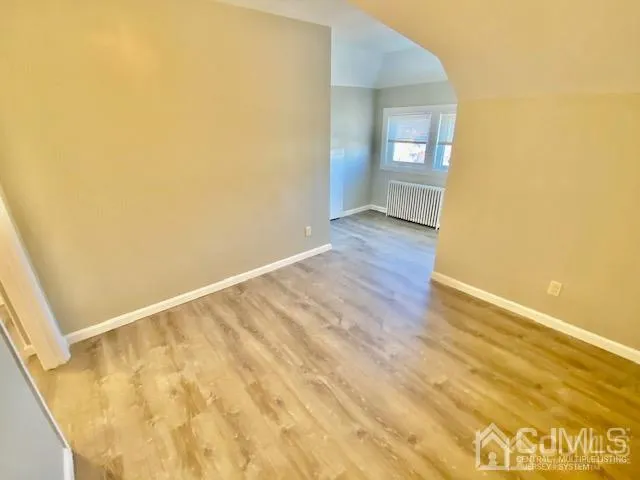a view of a hallway with wooden floor and closet