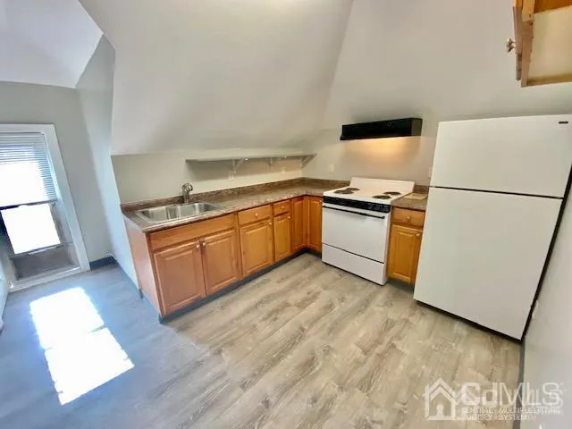 a kitchen with a stove top oven and white refrigerator