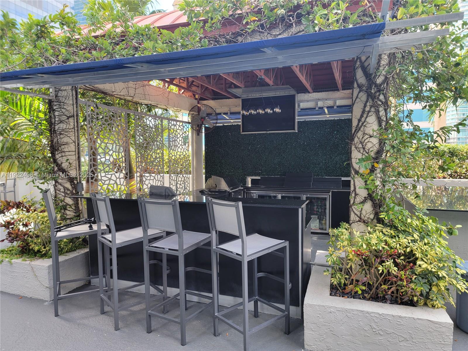 185 Southeast 14th Terrace, Unit 1101 Miami, FL 33131 - Photo 17 of 19 a view of a patio with table and chairs and potted plants