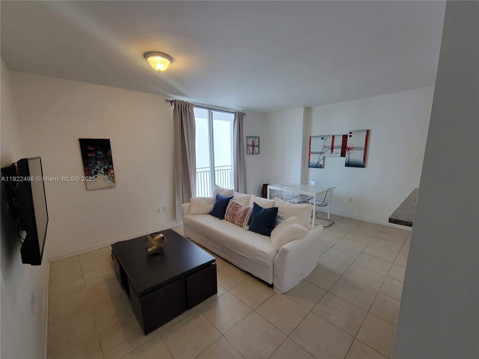 185 Southeast 14th Terrace, Unit 1101 Miami, FL 33131 - Photo 3 of 19 a living room with furniture and a flat screen tv