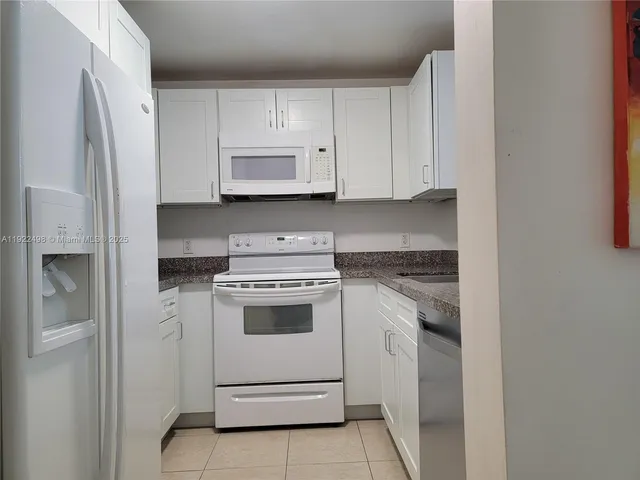 a kitchen with white cabinets and white appliances