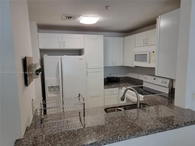 a kitchen with stainless steel appliances granite countertop a sink stove and cabinets