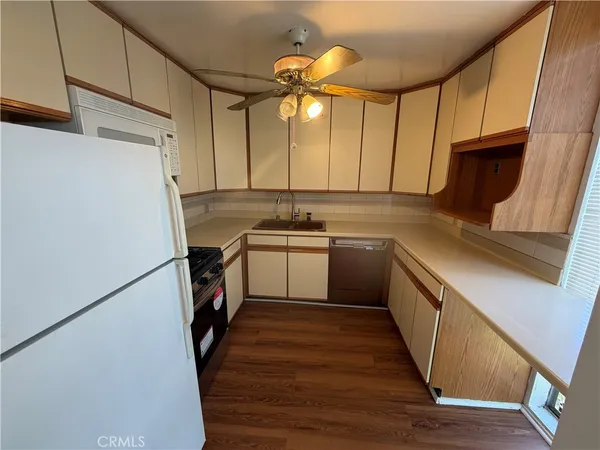 a kitchen with a sink a refrigerator a window and cabinets