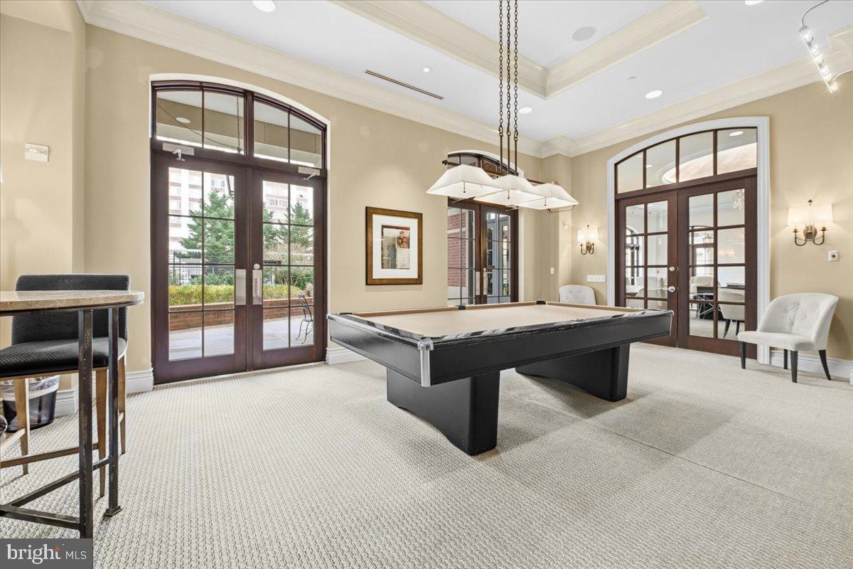 11710 Old Georgetown Road, Unit 121 North Bethesda, MD 20852 - Photo 25 of 35 a living room with furniture a chandelier and a flat screen tv