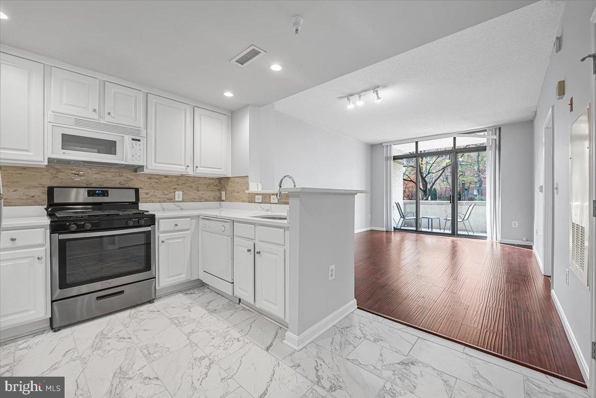 11710 Old Georgetown Road, Unit 121 North Bethesda, MD 20852 - Photo 3 of 35 a kitchen with stainless steel appliances granite countertop a stove a sink and white cabinets