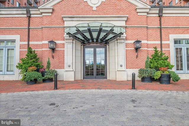a front view of a building with a garden and plants