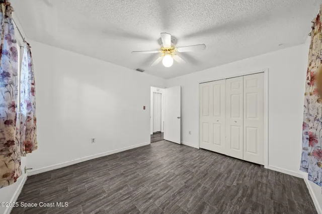 a view of an empty room and window a ceiling fan