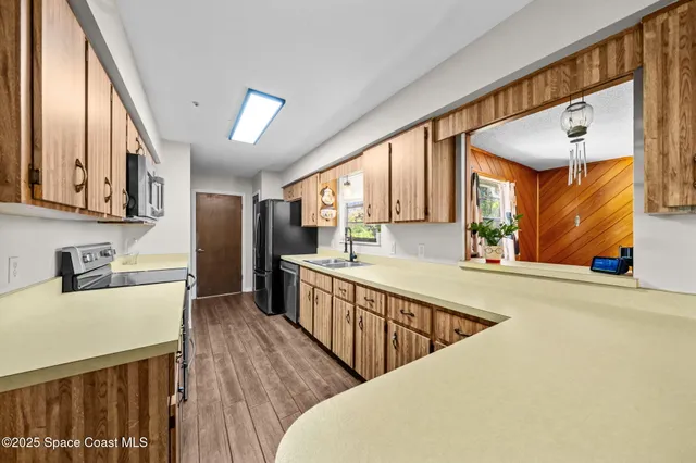 a kitchen with stainless steel appliances granite countertop a sink a stove and a refrigerator
