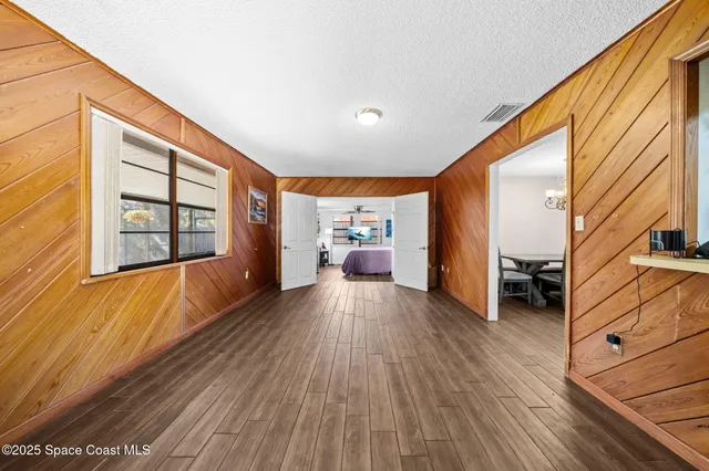 a view of a hallway with wooden floor and furniture