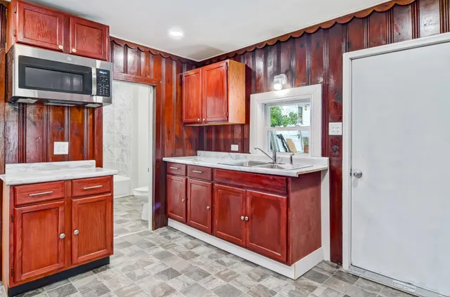 a kitchen with stainless steel appliances granite countertop a refrigerator and wooden cabinets
