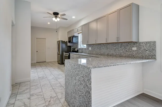 a kitchen with stainless steel appliances granite countertop a sink a stove and cabinets