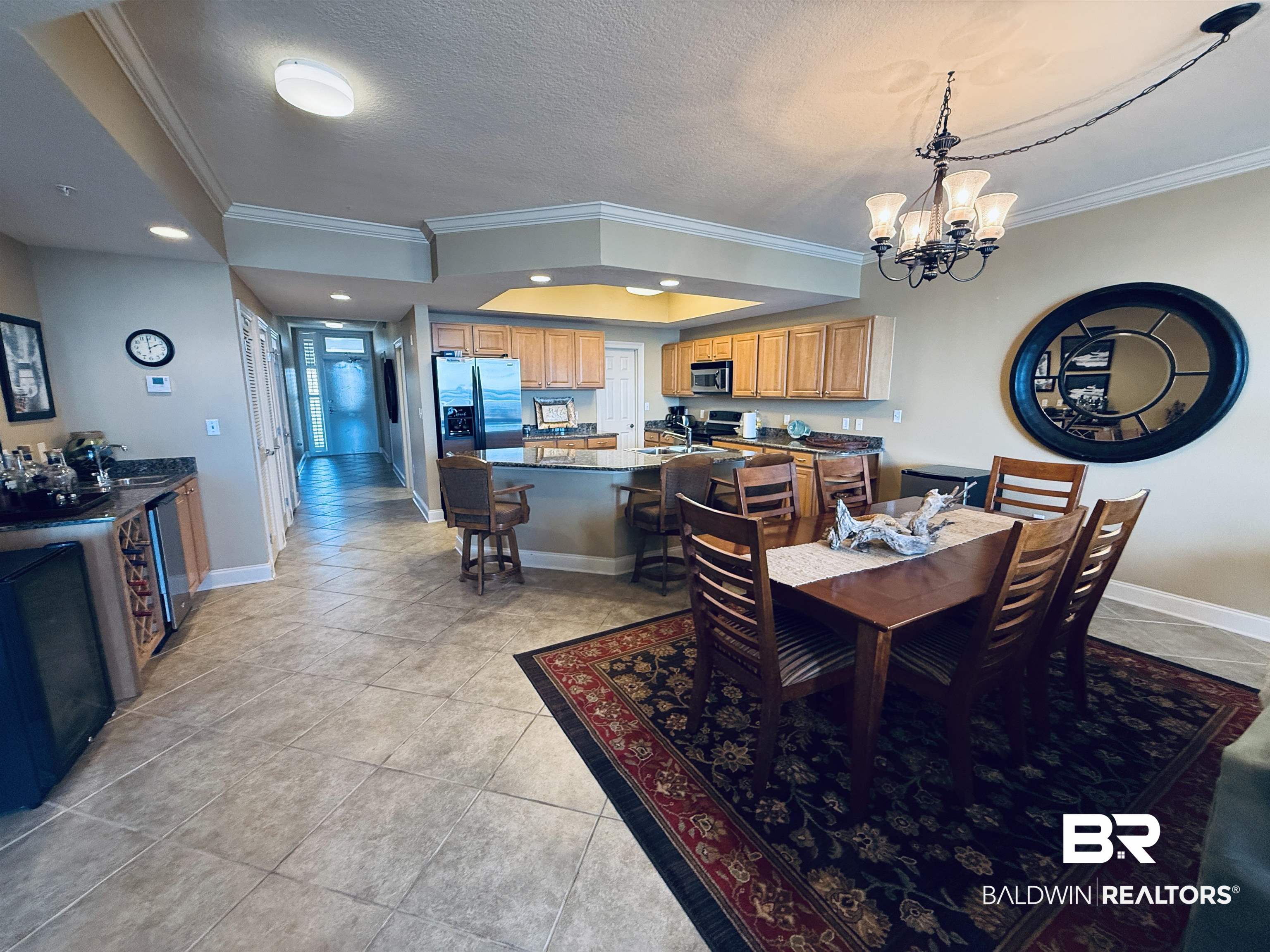 27800 Canal Road, Unit 409 Orange Beach, AL 36561 - Photo 22 of 22 Dining space with ornamental molding, a tray ceiling, hanging lights, light tile patterned floors, and a textured ceiling