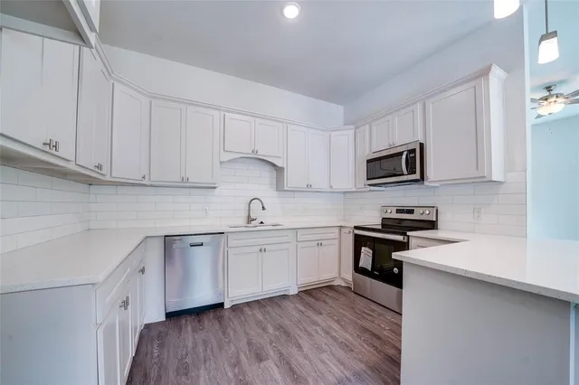 a kitchen with cabinets appliances a sink and a counter top space