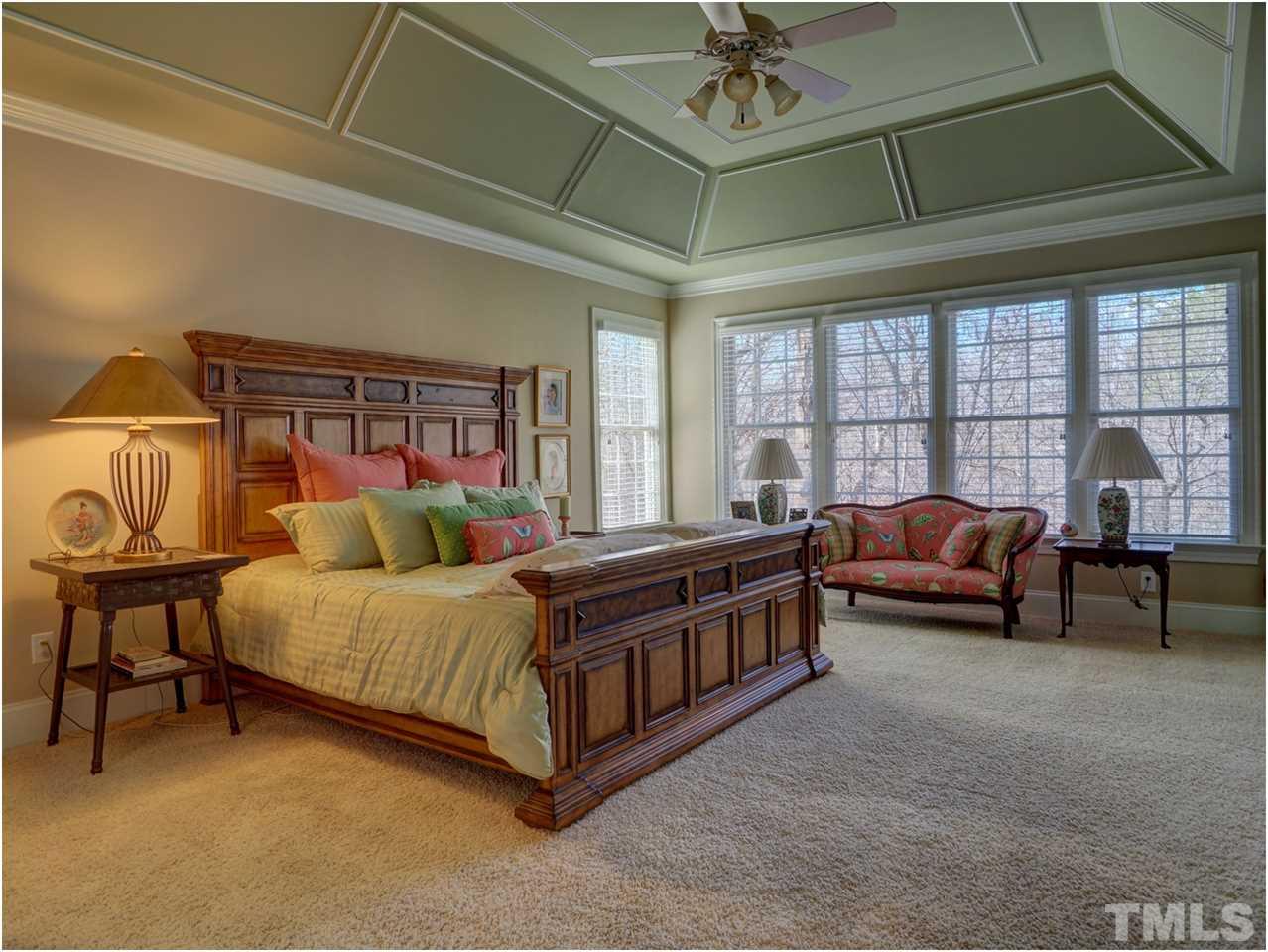3408 Ocotea Street Raleigh, NC 27607 - Photo 11 of 25 a spacious bedroom with a bed and a chandelier