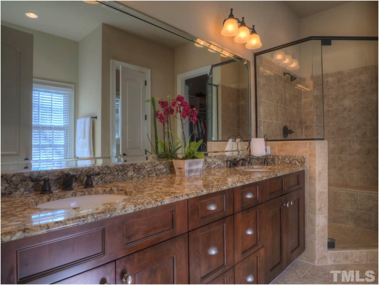 3408 Ocotea Street Raleigh, NC 27607 - Photo 12 of 25 a bathroom with a granite countertop sink and a mirror