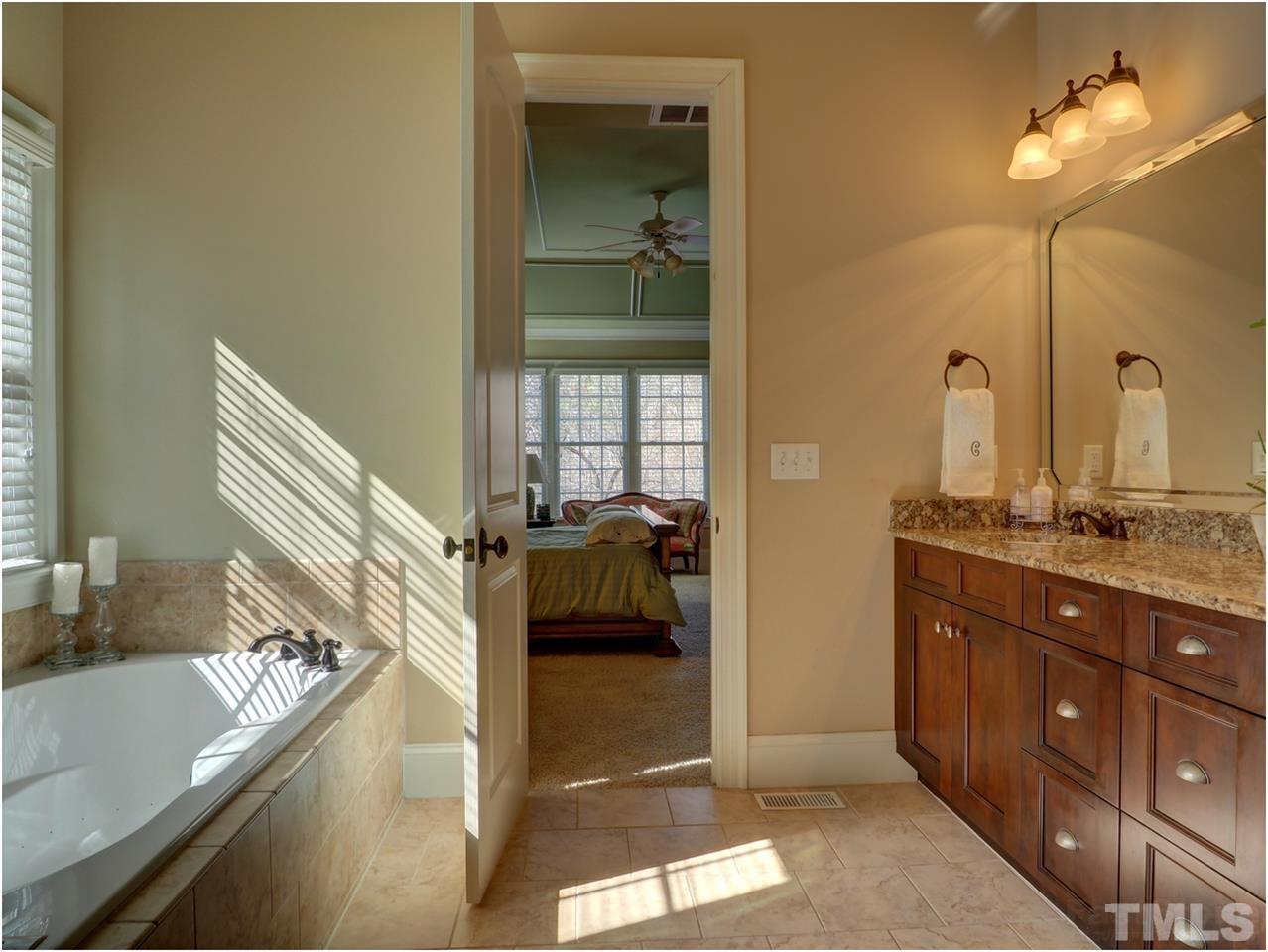 3408 Ocotea Street Raleigh, NC 27607 - Photo 13 of 25 a en suite bathroom with a sink and a mirror