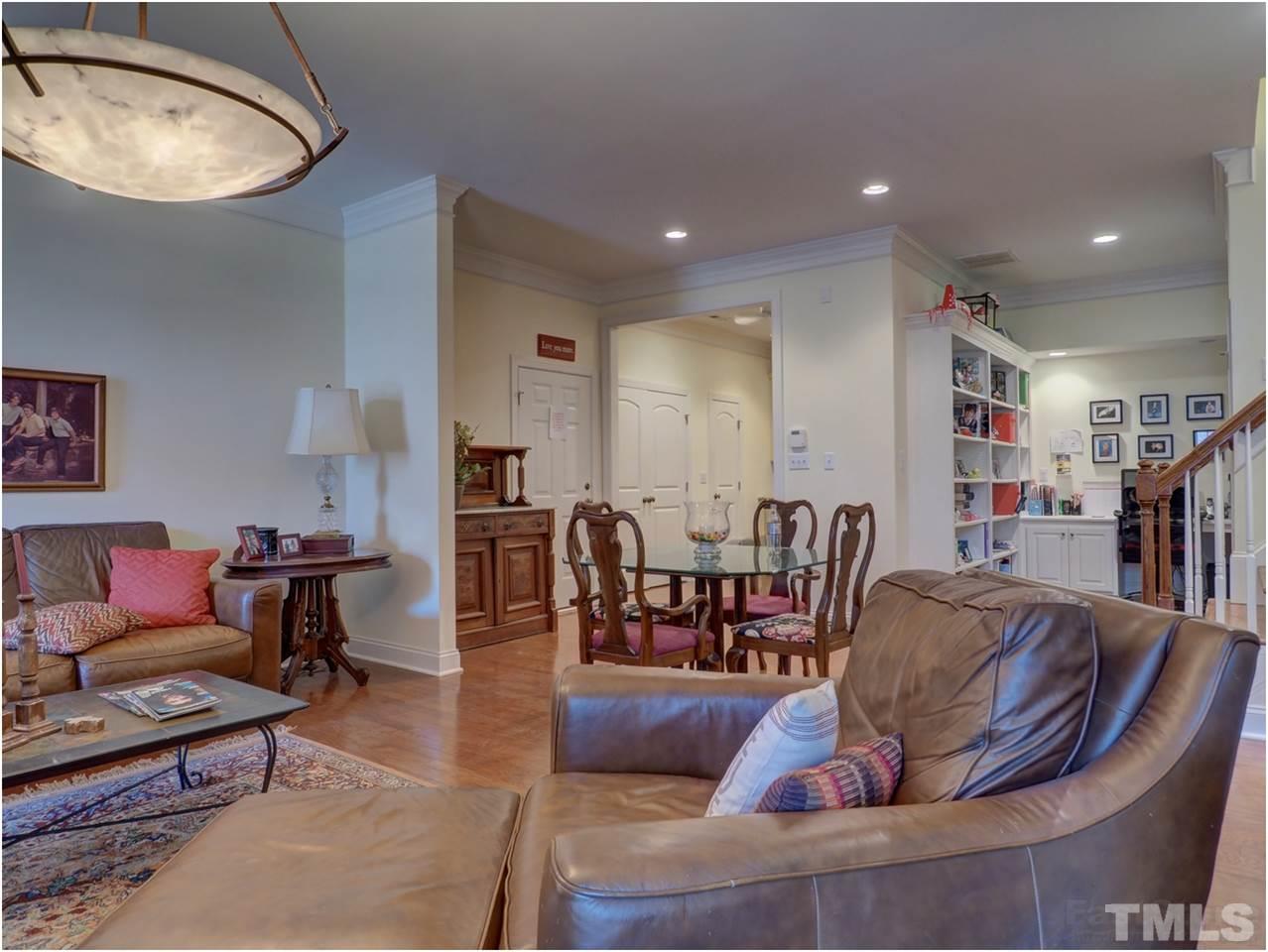 3408 Ocotea Street Raleigh, NC 27607 - Photo 18 of 25 a living room with furniture a wooden floor and kitchen view