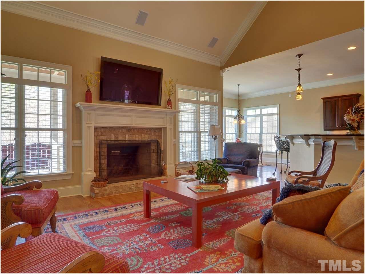3408 Ocotea Street Raleigh, NC 27607 - Photo 5 of 25 a living room with furniture a fireplace and a flat screen tv