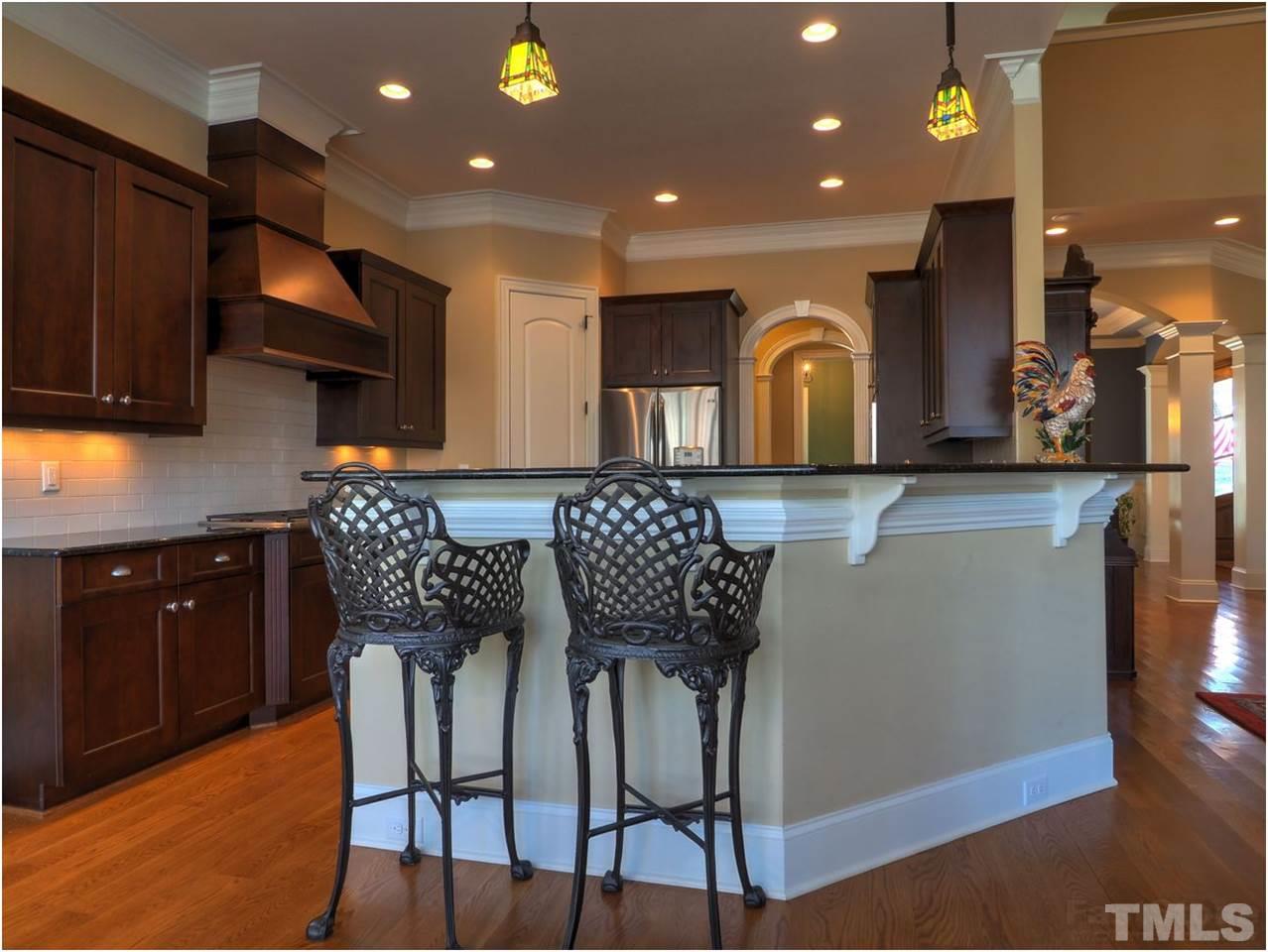 3408 Ocotea Street Raleigh, NC 27607 - Photo 10 of 25 a kitchen with stainless steel appliances granite countertop a table chairs and wooden cabinets
