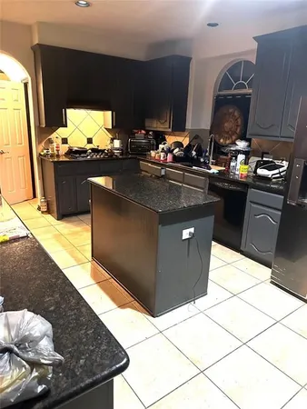 a kitchen with stainless steel appliances kitchen island granite countertop a stove and a sink