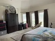 a bedroom with a bed a mirror and a large window