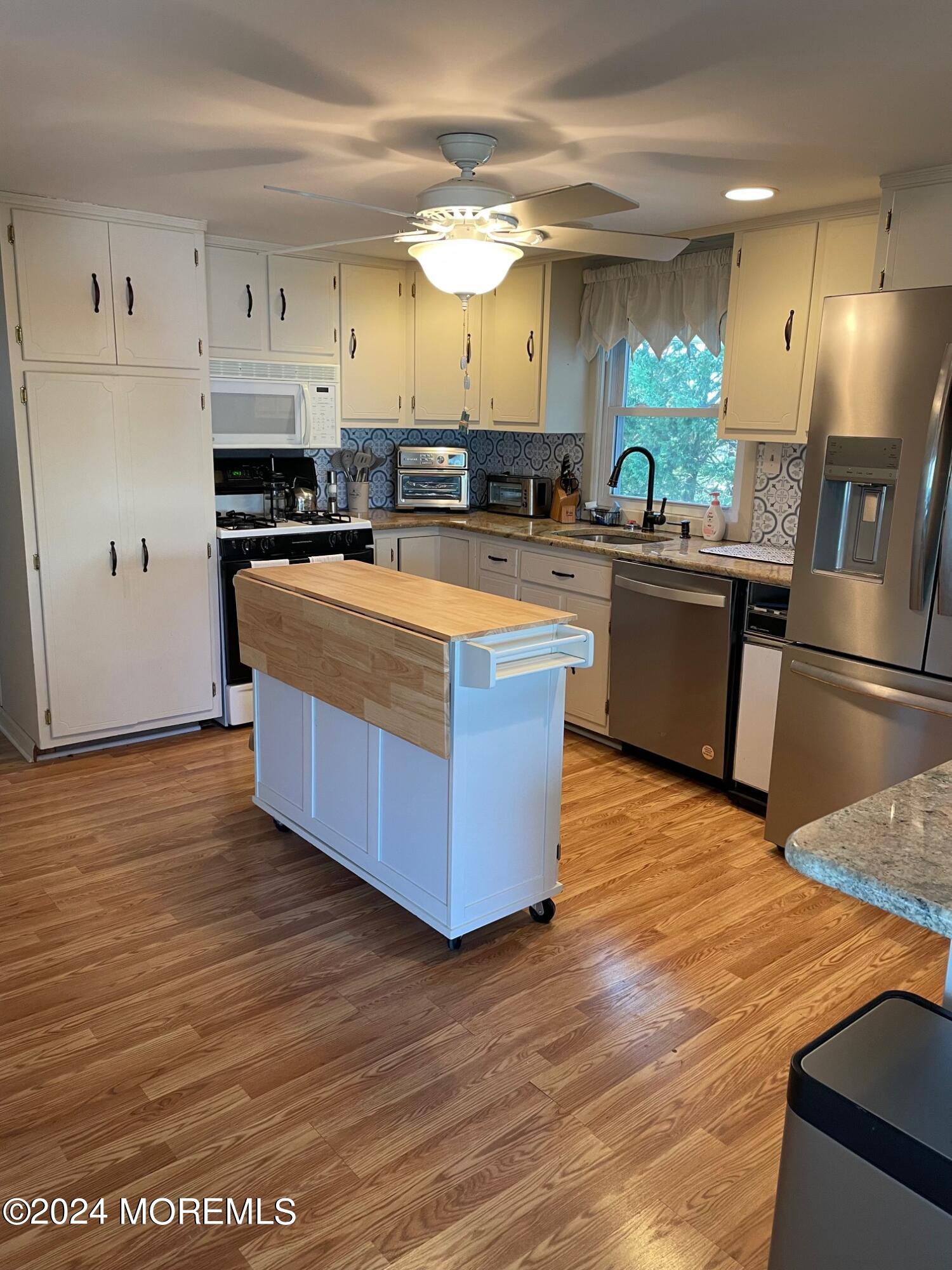 77 Jib Lane Brick, NJ 08723 - Photo 4 of 23 a large kitchen with stainless steel appliances granite countertop a large counter top a stove a refrigerator and a microwave