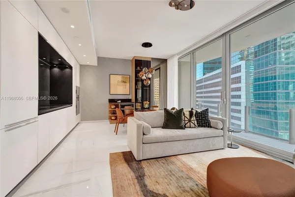 a living room with furniture kitchen view and a window