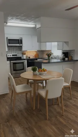 a kitchen with a table chairs stove and cabinets