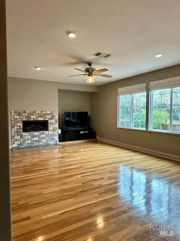 a view of empty room with wooden floor and fireplace