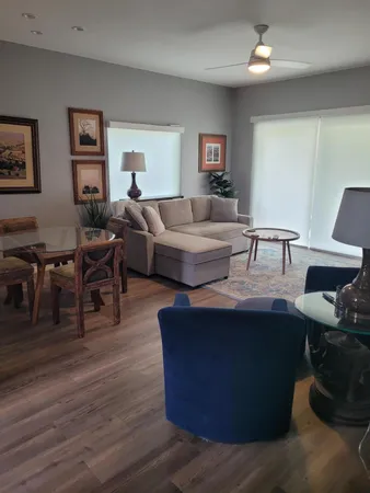 a living room with furniture and wooden floor