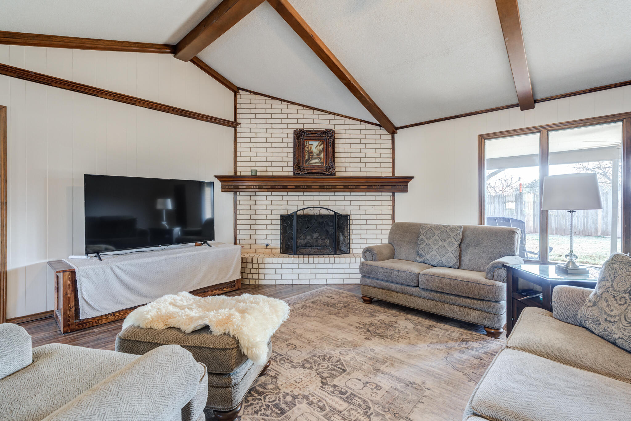 5703 80th Street Lubbock, TX 79424 - Photo 14 of 45 a living room with furniture a flat screen tv and a fireplace