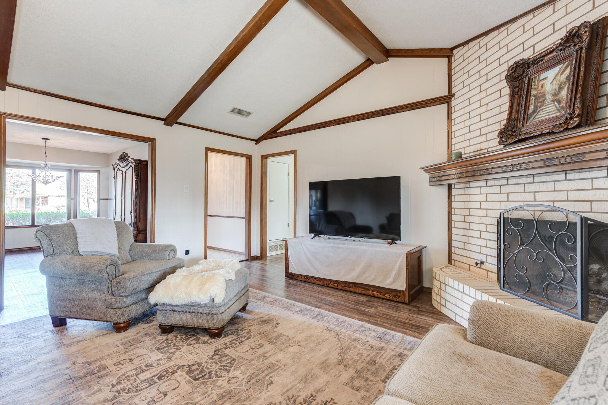 5703 80th Street Lubbock, TX 79424 - Photo 16 of 45 a living room with furniture a flat screen tv and a fireplace