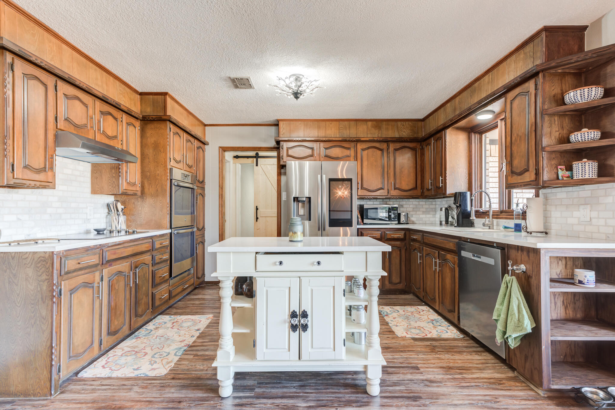 5703 80th Street Lubbock, TX 79424 - Photo 21 of 45 a large kitchen with stainless steel appliances granite countertop a stove a sink dishwasher and a refrigerator